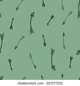 Ethnic seamless pattern. Texture with tribal hand drawn arrows. Native american design. Backdrop with vintage arrows. Black doodle elements on the green background. Vector illustration.