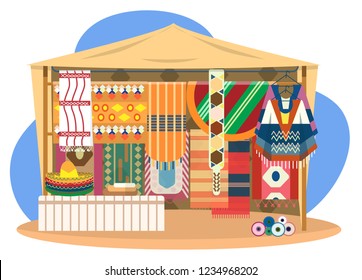 Ethnic souvenir street shop. Mexican street store with carpets,mats, ponchos, sombrero hats and fabrics rolls.