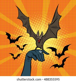 Evil bat sitting on the hand, pop art retro vector illustration. Halloween