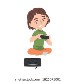 Excited Girl Sitting on Floor with Joystick, Kid Playing Video Game Cartoon Style Vector Illustration