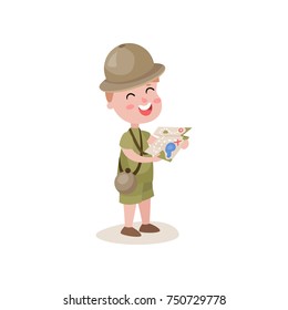 Excited little boy scout holding map in hands, summer camp activities