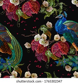 Exotic birds. Colorful peacocks, red pomegranate fruit and white flowers. Fashion tropical seamless pattern. Fashionable template for design of clothes, textile 