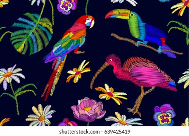 Pássaros exóticos paraíso. Padrão vetorial sem costura com papagaio bordado, tucano e ibis em fundo azul escuro. Coleção têxtil de praia.
