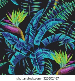 Exotic tropical plants and flowers in the jungle night. Seamless vector illustration pattern on a black background palm leaves in trendy blue style
