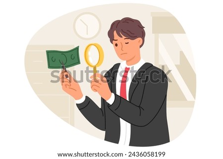 Expert examines counterfeit dollar money by using magnifying glass to look for inaccuracies in fake banknotes. Fake money printed by criminal in hands of inspector investigating crime