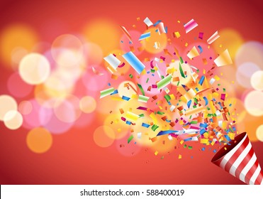 Exploding party popper on colorful defocused blurred background