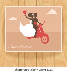 Extreme wedding. The bride and groom on a motorcycle. Card on wooden texture