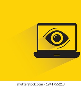 escáner ocular en un portátil con sombra sobre fondo amarillo