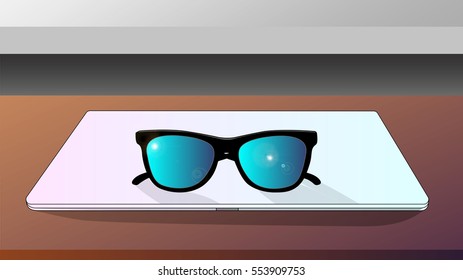 Eyeglasses with laptop on the desk.