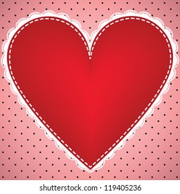 Fabric heart with lace on polka dot background.