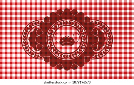 Face mask icon inside red checkered tablecloth realistic emblem. Restaurant fashionable background. Vector illustration. 