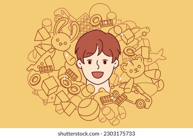 Face of teenager boy among toys and constructor for entertainment or development of child. Cheerful boy from kindergarten laughing enjoying happy childhood and abundance of toys for spending time