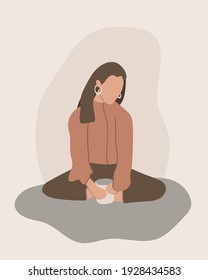 Faceless portrait of a girl sitting on the floor holding a mug of hot tea, meditation, self care concept