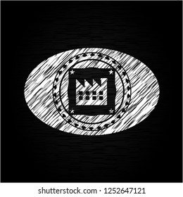 factory icon inside chalk emblem written on a blackboard