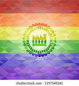 factory icon inside emblem on mosaic background with the colors of the LGBT flag