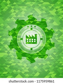factory icon inside green emblem with triangle mosaic background
