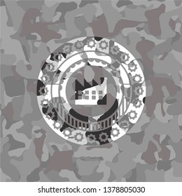 factory icon inside grey camouflaged emblem