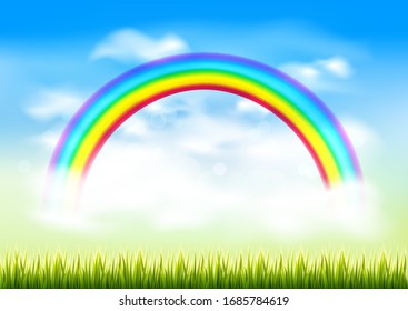 Fairytale summer landscape with blue sky, rainbow and green grass.