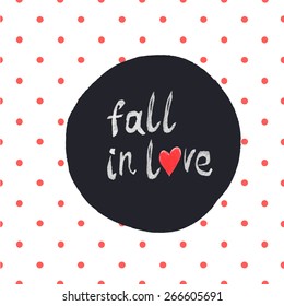 "Fall in love" lettering with hand-drawn heart symbol on seamless red polka dot pattern