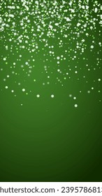 La caída de los copos de nieve hace el fondo de la navidad. Sutiles copos de nieve volando y estrellas sobre fondo verde navideño. Los copos de nieve que caían con belleza se superponen. Ilustración vectorial vertical.