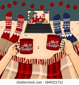 Family And Friends Have A Fun Christmas Party Via Laptop Via Video Call On The Bed With Cups Of Coffee Or Hot Chocolate Under Plaid