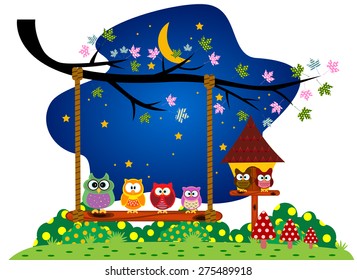 Family Owls sitting on a swing under a tree at the park