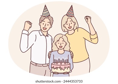 Family of parents with daughter celebrating birthday posing with cake and candles for joint photo. Mother and father together with pre-teenage girl celebrating birthday party making joyful gestures