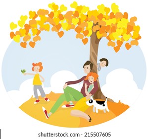 Family sitting under autumn tree