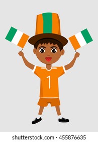 Fan of Cote divoire national football team, sports. Boy with flag in the colors of the state command with sports paraphernalia.