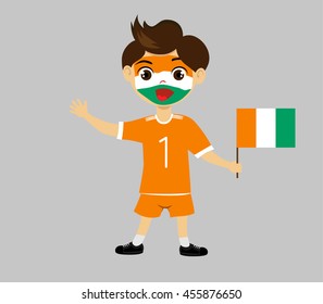 Fan of Cote divoire national football team, sports. Boy with flag in the colors of the state command with sports paraphernalia.