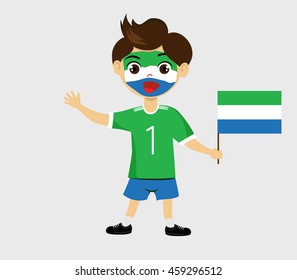 Fan of Sierra Leone national football team, sports. Boy with flag in the colors of the state command with sports paraphernalia.