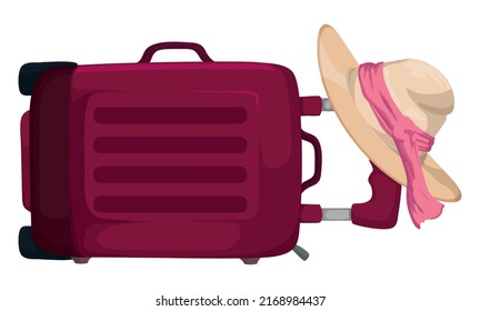 Fancy suit case laid down on the floor, with stylised woman's hat decorated with red fabric.