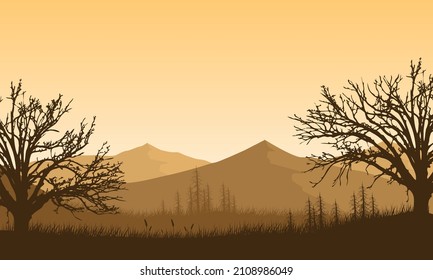 Fantastic mountain panorama with dry tree silhouettes from the outskirts of the city at sunset in the afternoon