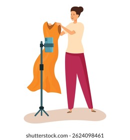 Fashion blogger está ajustando um vestido laranja em um manequim e gravando conteúdo de vídeo