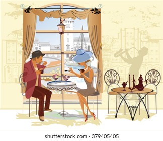 Fashion couple, man and woman,  drinking coffee at the street cafe.