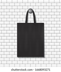 Fashion eco tote bag mockup hanging on wall background. School handbag for reusable. Black canvas sack with handles. Cotton bag for shopping retail. Handbag mock up hanging on nail. Design vector