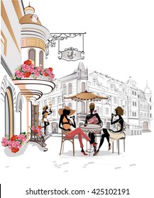 Fashion girls in the street cafe. Street cafe with flowers in the old city.