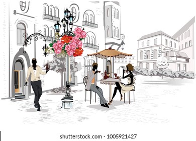 Fashion people in the street cafe. Street cafe with flowers in the old city. Waiters serve the tables. 