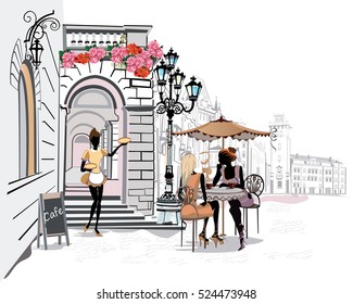 Fashion people in the street cafe. Restaurant with flowers in the old city. Waiters serve the tables.