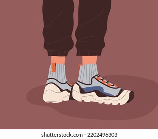 Fashion Unisex Sneakers And Socks On Human Feet. Modern Sport Shoes Pair, Athletic Footwear On Legs In Pants. Stylish Trendy Sporty Comfortable Footgear Model. Colored Flat Vector Illustration