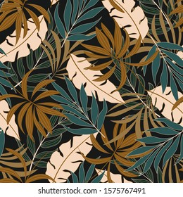 Fashionable seamless tropical pattern with bright yellow and blue plants and leaves on black background. Beautiful seamless vector floral pattern. Tropic leaves in bright colors.