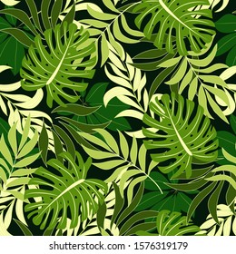 Fashionable seamless tropical pattern with bright green plants and leaves on dark background. Vector design. Jungle print. Floral background.  Printing and textiles.Exotic jungle wallpaper. 