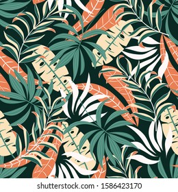 Fashionable seamless tropical pattern with bright pink and green plants and leaves on dark background. Exotic tropics. Summer. Modern abstract design for fabric, paper, interior decor.