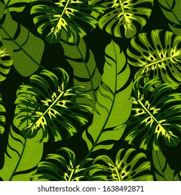 Fashionable seamless tropical pattern with bright green plants and leaves on a dark background. Modern abstract design for fabric, paper, interior decor. Exotic jungle wallpaper. 
Hawaiian style.