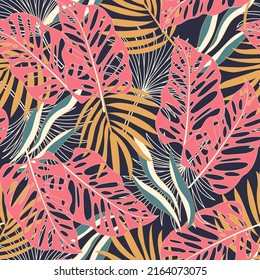 Fashionable seamless tropical pattern with bright plants and leaves on a dark background. Seamless pattern with colorful leaves and plants. Tropic leaves in bright colors. Beautiful seamless.