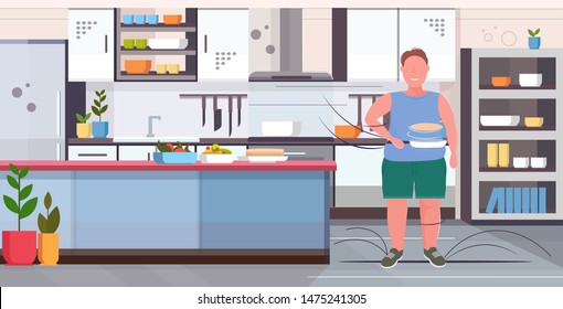 fat obese man preparing fresh pancakes in frying pan unhealthy nutrition obesity concept overweight guy standing pose modern kitchen interior flat full length horizontal