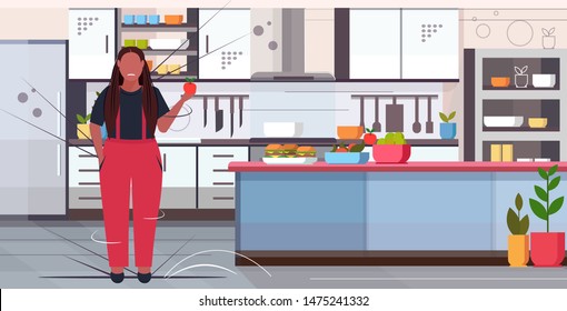fat obese woman holding apple african american overweight girl choosing between fresh fruits and hamburgers unhealthy junk food weight loss diet concept kitchen interior full length horizontal