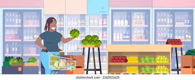 fat obese woman with shopping trolley cart choosing groceries weight loss concept overweight african american girl supermarket customer grocery shop interior horizontal portrait