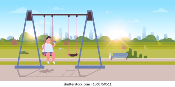 fat overweight boy holding ice cream sitting on swing outdoor obese overweight guy swinging eating fast food unhealthy lifestyle concept landscape sunrise background full length flat