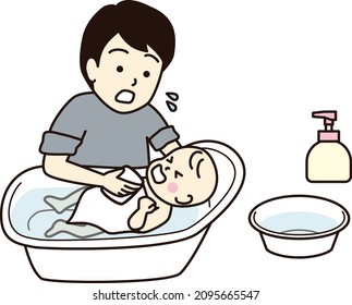 Father bathing a crying baby in a baby bath.